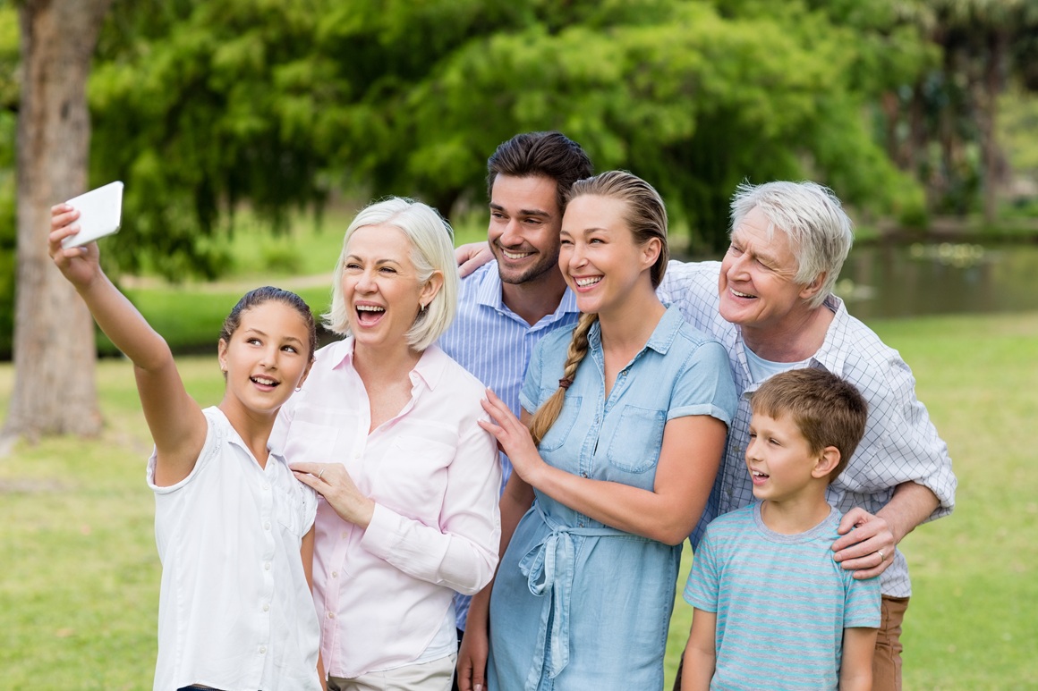 Multi-generation family taking a selfie on a mobile phone in park